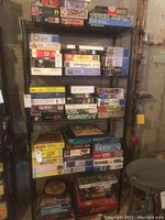 Photo of the metal wire storage shelf holding multiple boxes of jigsaw puzzles, showing shelf structure and contents.