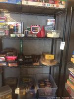 Overview of metal shelving unit with various boxed contents but contents not included in the lot.