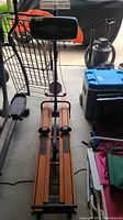 Front view of NordicTrack skiing exercise machine showing wooden slats, foot pedals, and padded seat backrest