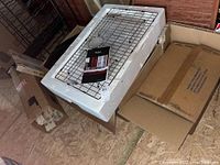 Photo of Kraus stainless steel undermount kitchen sink packaging with a stainless steel rack and instruction booklet on top.