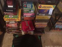 Photo showing stacked board games including Pictionary, Scrabble, Password, Bingo, Clue, Carmen Sandiego, and The Worst-Case Scenario Survival Game