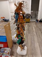 Full view of the tall white wood stand packed with various Beanie Babies hanging by elastics, showing multiple plush animals including elephants, bears, and more.