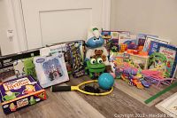 Full view of lot with puzzles, toys, books, and board game displayed on floor showing condition and assortment