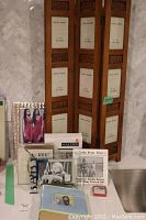 Wood folding picture frame stand showing multiple slots and various new photo albums and frames in front