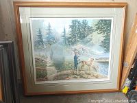 Full view of framed print showing boy, dog and lakeside forest scene