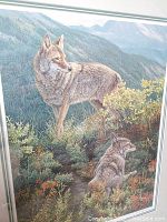 Close-up photo of the print showing detailed rendering of two wolves in natural mountain surroundings with plants and distant hills