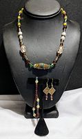 Full view of 3 piece jewelry set displayed on a black stand: necklace with mixed beads including glass and pearls, dangle earrings, and a beaded bracelet.