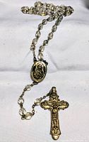 Full rosary laid out, showing crystal beads, medallion and crucifix