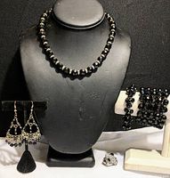 Full set displayed with necklace on stand, bracelets and ring on white display stands, earrings on black stand