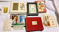 Lot display of five collectible playing card decks with various illustrated boxes and cards laid out.