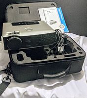 Dell 2400MP projector sitting in black foam-padded carry case with power/video cords and owner's manuals.