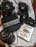 Multiple DJ lighting units including American DJ XP3, American DJ Zodiac, Chauvet Mushroom, and a silver Soundtracs lighting controller arranged on a white cloth.