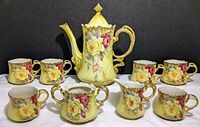 Full set of 9 Nippon china pieces including coffee pot, creamer, sugar bowl, and 6 cups showing yellow base with floral designs and gold handles.