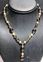 Full view of the necklace displayed on a black bust showing the combination of smokey quartz beads and pearls.