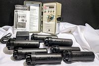 7 Rainbird Model 5000 black plastic sprinkler heads arranged with power adapter visible