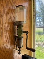 Front view of the entire wall-mounted grinder mounted on wood panel