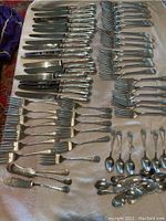 Overall layout of all 71 flatware pieces on white towel