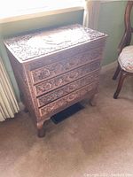 Front view of carved wooden cabinet with four drawers