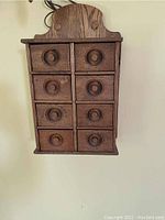 Front view of oak hanging cabinet showing eight drawers