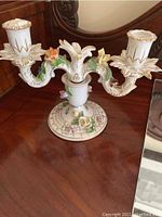 Front view of large porcelain candelabra with floral detail and gold trim