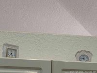 Two square decorative cut glass table clocks mounted on a wall, positioned side by side.