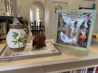 Floral placemats, ceramic pitcher, wooden coasters, and boxed tea set on countertop