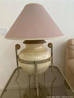 Full view of the large ceramic table lamp with metal stand and rose colored shade.