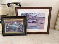 Both framed wall art prints shown together leaning against a wall on the floor.