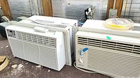 Two window air conditioners side by side: GE AEL08LVQ1 with remote on top, Gold Star R5208 with rotary control knobs and horizontal vents.