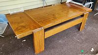Front side of the solid wooden coffee table with visible woodgrain on the top surface and sturdy legs.