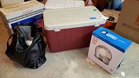 Photo of two Coleman coolers, vinyl tote bag, Sunbeam cool spray humidifier, and small fan in original boxes, all placed on a concrete floor.