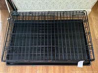 Top view photo of the black metal wire dog crate with the tray inside, showing the full crate structure and dimensions.