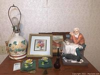 Full lot view including lamp, framed prints, figurine, wall hangings and Avon bottle