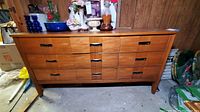 Front and angled views of the 9-drawer wooden dresser in a basement setting, showing condition and overall design.
