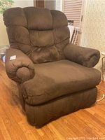 Front angled view of brown fabric recliner chair showing plush padded cushions and armrests.