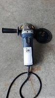 Top view of Mastercraft angle grinder showing power cord, side handle, and detached grinding disc.