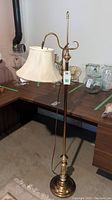 Full view of the vintage brass floor lamp with fabric shade, showing the bridge arm and shade placement.
