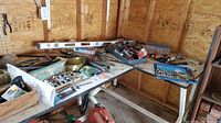 Wide view of workbench with assorted hand tools, screwdrivers, saws, and level