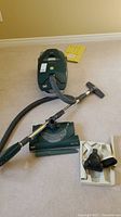 Overall view of canister vacuum, power head, hose, wand, attachments tray and filter pack