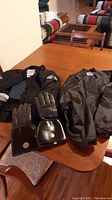 Joe Rocket women's motorcycle jacket and Road Krome leather gloves displayed on a table.