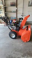Side profile of entire snowblower in garage
