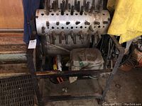 Full view of the metal chicken feather rolling machine on a frame with spring-loaded rods protruding