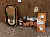 View of 11x21 clock, box of candles, battery packs and wooden panel barometer set