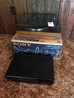 Turntable on top of Sony CDP-CE215 box with Sony CD player in front, showcasing the lot items