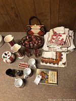 Overall lot showing kitchen linens, handbag, vases, mugs, decorative eggs in bowl, and cooking book.