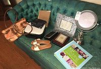 Full lot overview showing purse, sandals, planner, camera case, frames and makeup mirror on green couch