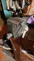 Close-up of green cast-iron bench vise mounted to bench