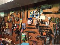 Full wall pegboard with various hand tools, tape measures, tin snips, pliers and metal file.