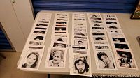 Black-and-white photographic portraits of various actors and actresses arranged in rows on a table