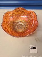 Orange gradient carnival glass bowl showing detailed patterns and scalloped edge from top view